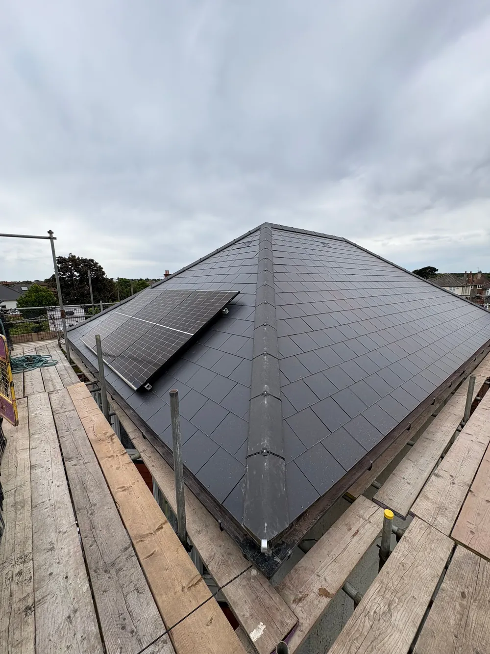 After: the hip roof re-slated in Jutland man-made slate with grey Modern ridges and the solar panels refitted