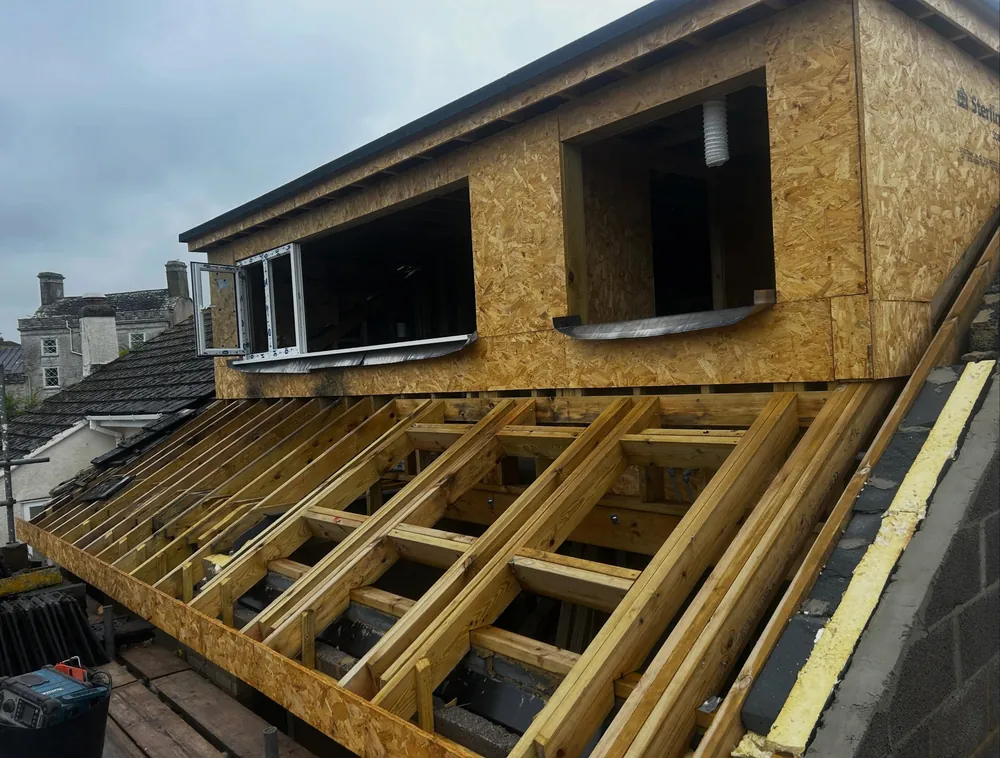 Loft dormer extension in Swanage framed in OSB with the new rafters exposed, ready for three Velux windows and the existing tiles to go back on